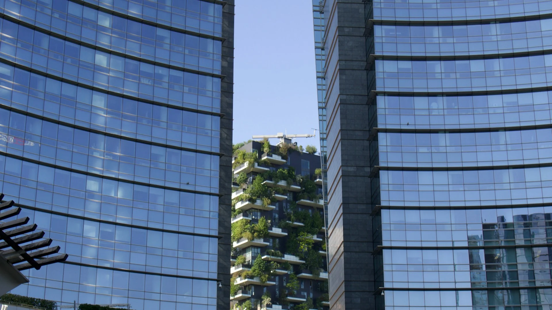 Bosco Verticale framed between modern office towers in Milan's Porta Nuova district, illustrating the city's appeal for international luxury real estate investors and developers - KiTalent