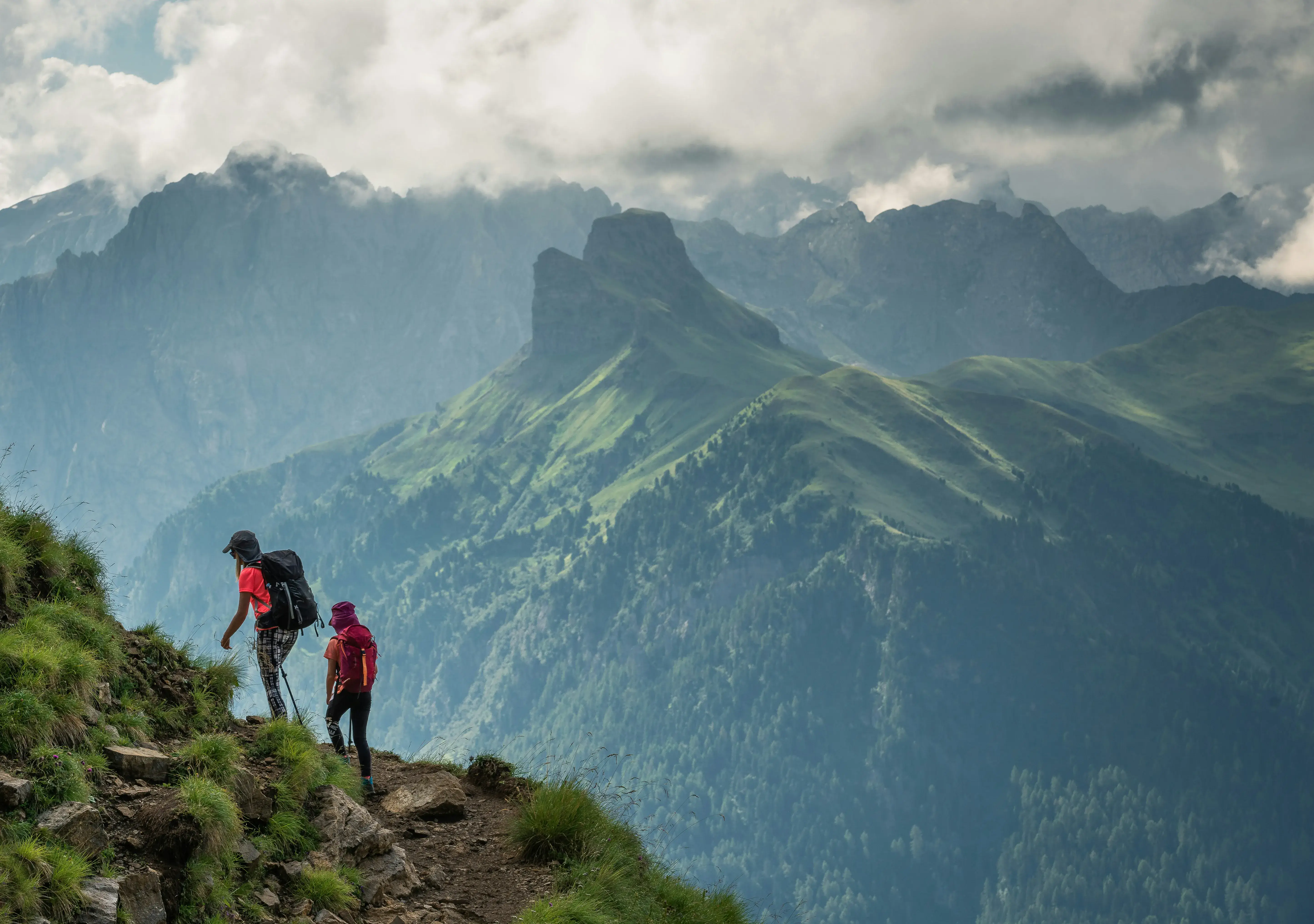 Expedition leader guiding a group through a dramatic mountain landscape, symbolising immersive experiential travel leadership. - KiTalent